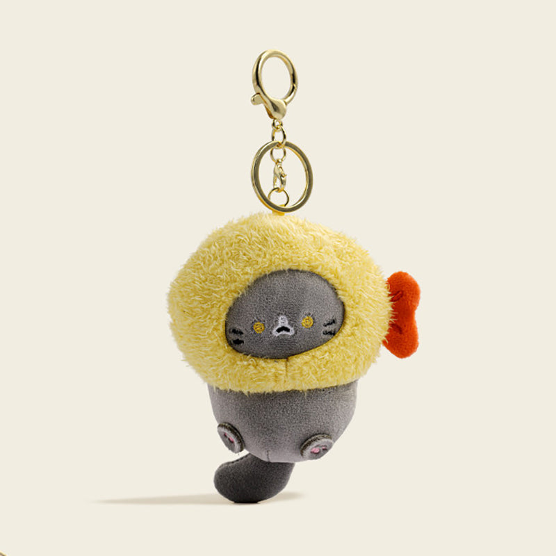A plush yellow cat bag charm inside a golden-brown Fried shrimp-shaped costume with embroidered whiskers and pink paw details. It is attached to a gold lobster clasp and keyring, designed as a cute and trendy accessory for bags or keychains.