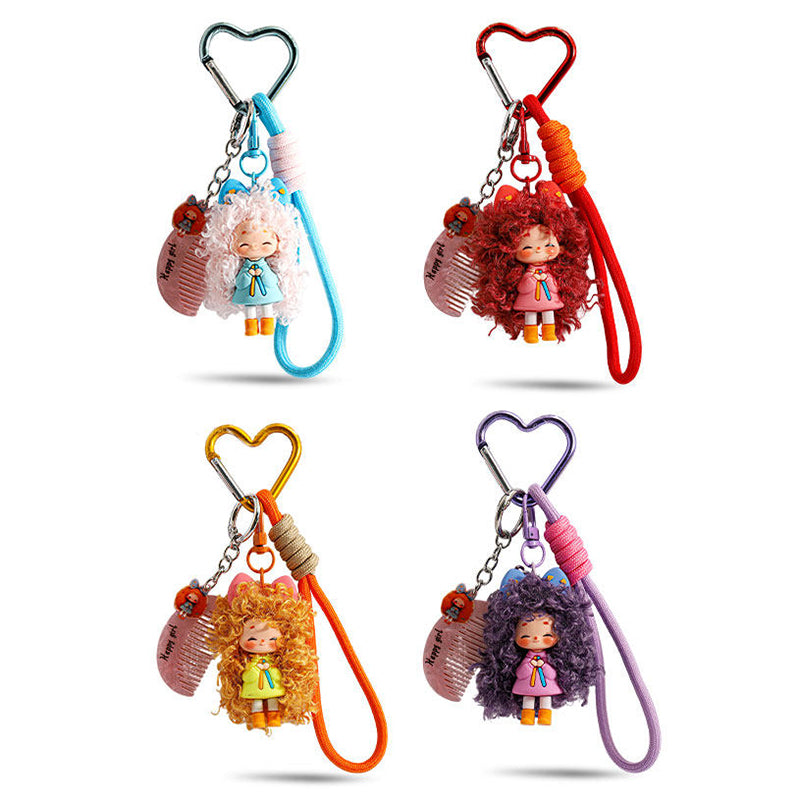A collection of four colorful doll keychains arranged in a grid. The set includes variations in white/blue, red/pink, orange/green, and purple/pink, each with a heart clip and comb charm.