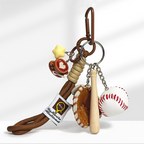 A baseball-themed keychain with a brown carabiner clip, featuring a yellow star charm, a brown coffee cup charm with a white heart design, a brown leather baseball glove, a wooden baseball bat, and a white baseball with red stitching, attached to a braided rope strap.