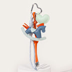 A pastel-colored leather keychain featuring a blue rocking horse and a mint green heart charm. It is decorated with orange tassels and hangs from grey and orange cords attached to a silver hook.