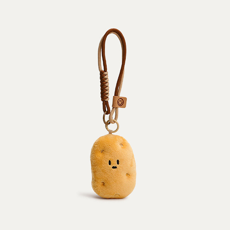 A cute plush potato keychain with a simple smiling face, attached to a brown leather strap with a woven detail and a small leather tag featuring a smiley face logo. The keychain is designed as a trendy and adorable accessory for bags or keys.