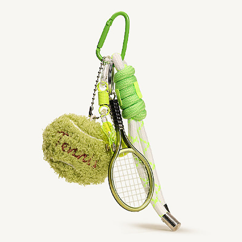 A close-up of a green tennis-themed keychain set, featuring a fuzzy tennis ball with 'Tennis' embroidered in red, a miniature gold-framed racket, and a white rope handle with green accents, all attached to a green carabiner.