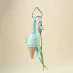 A mint green leather ice cream cone bag charm with a white scalloped edge and perforated details, attached to a silver carabiner clip. It features mint green and light green ribbons, a pearl chain, and a small silver heart charm, designed as a cute and trendy accessory for bags or keychains.