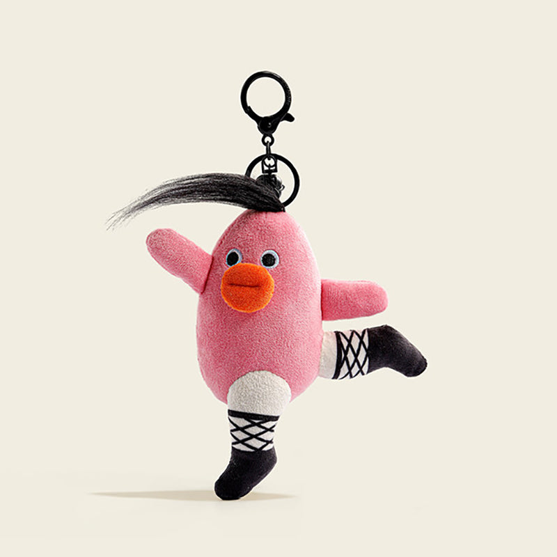 A plush bird-shaped bag charm in pink fabric with black socks featuring white crisscross patterns, an orange beak, and a black feather on its head. It is attached to a black carabiner clip, designed as a playful and stylish accessory for bags or keychains.