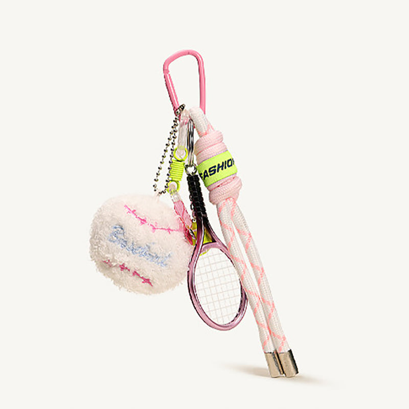 A pink tennis-themed keychain set, including a plush white tennis ball with pink stitching and a miniature pink racket, is shown against a plain white background, highlighting its design details.