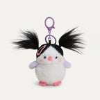 A plush bird keychain with a white body, black head, and lavender wings. It has black, pigtails, a pink hair clip, and a purple metal clasp.