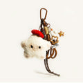 A white plush star-shaped doll with black eyes and a red knitted hat, attached to a brown carabiner with woven cords and decorative elements including a star-shaped acrylic piece and beads.