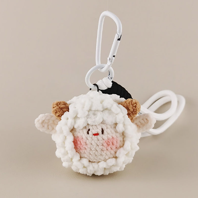 A close-up of a white crocheted sheep plush keychain with brown ears and a smiling face, attached to a white carabiner clip.