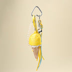 A yellow leather ice cream cone bag charm with a white scalloped edge and perforated details, attached to a silver carabiner clip. It features yellow and light blue ribbons, a pearl chain, and a small silver heart charm, designed as a cute and trendy accessory for bags or keychains.