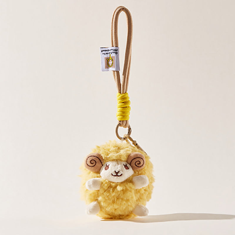 A front-facing view of a yellow fluffy sheep plush keychain with brown spiral horns and a smiling face, attached to a beige cord with a yellow wrap and a small branded tag.